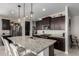 Modern kitchen featuring dark wood cabinets, stainless steel appliances, and granite countertops at 17454 W Red Fox Rd, Surprise, AZ 85387