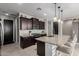 Well-appointed kitchen with an island, granite countertops, stainless steel appliances, and dark wood cabinets at 17454 W Red Fox Rd, Surprise, AZ 85387