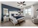 Stylish main bedroom with a large window, ceiling fan, and en-suite bathroom access at 17454 W Red Fox Rd, Surprise, AZ 85387