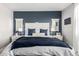 Stylish main bedroom featuring a blue accent wall, bedside tables with lamps, and a comfortable king bed at 17454 W Red Fox Rd, Surprise, AZ 85387