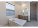 Modern bathroom featuring a soaking tub, vanity with double sinks, and glass-enclosed shower at 21430 W Meadowbrook Ave, Buckeye, AZ 85396