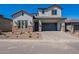 Charming two-story home with a gray stucco exterior, brick accents, and a paved driveway at 21430 W Meadowbrook Ave, Buckeye, AZ 85396