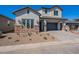 Charming two-story home with a gray stucco exterior, brick accents, and a paved driveway at 21430 W Meadowbrook Ave, Buckeye, AZ 85396
