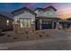 Charming two-story home with a gray stucco exterior, brick accents, and a paved driveway at 21430 W Meadowbrook Ave, Buckeye, AZ 85396