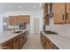 Spacious kitchen featuring stainless steel appliances, wood cabinetry, and a large center island with quartz countertops at 21430 W Meadowbrook Ave, Buckeye, AZ 85396