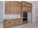 Gourmet kitchen boasts wooden cabinets, stainless steel appliances, and a white countertop at 21430 W Meadowbrook Ave, Buckeye, AZ 85396