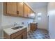 Well-equipped laundry room with ample cabinet space, granite countertop, and stylish tile floor at 21430 W Meadowbrook Ave, Buckeye, AZ 85396