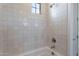White tiled shower and chrome fixtures are showcased in this beautifully appointed bathroom at 21430 W Meadowbrook Ave, Buckeye, AZ 85396