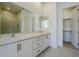 Bathroom featuring a double vanity, large mirror, and tiled shower with glass enclosure at 21450 W Meadowbrook Ave, Buckeye, AZ 85396