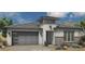 Modern prairie-style home featuring a two-car garage, decorative brick, and clerestory above the entry at 21450 W Meadowbrook Ave, Buckeye, AZ 85396