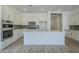 Modern kitchen with gray backsplash, stainless appliances, white cabinetry and a large island at 21450 W Meadowbrook Ave, Buckeye, AZ 85396