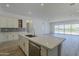 Modern kitchen with an island and a view into the adjacent living and dining area at 21450 W Meadowbrook Ave, Buckeye, AZ 85396