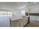 Modern kitchen featuring white cabinetry, stone countertops and a large center island with sink at 21450 W Meadowbrook Ave, Buckeye, AZ 85396