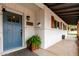 Welcoming entry featuring a vibrant blue front door, a fern planter, and charming architectural details at 2221 W De Palma Cir, Mesa, AZ 85202