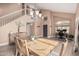 Dining area featuring a rustic wood table, view of the staircase, and modern chandelier at 22337 E Via Del Palo --, Queen Creek, AZ 85142