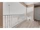 Light-filled hallway with wood-look floors, white railing, and chandelier hanging down at 22337 E Via Del Palo --, Queen Creek, AZ 85142