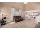 Cozy living room with wood-look floors, a brown sofa, and an open layout to the dining and kitchen areas at 22337 E Via Del Palo --, Queen Creek, AZ 85142
