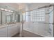 Bright bathroom featuring tile shower, glass block window and double vanity at 3120 E Squaw Peak Cir, Phoenix, AZ 85016