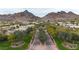 Scenic view of the neighborhood with lush landscaping and mature trees with mountains in the background at 3120 E Squaw Peak Cir, Phoenix, AZ 85016