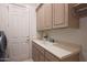 Laundry room with sink, cabinets and door at 3120 E Squaw Peak Cir, Phoenix, AZ 85016