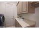 Functional laundry room with ample cabinet space and utility sink at 3120 E Squaw Peak Cir, Phoenix, AZ 85016