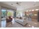 Open-concept living room featuring a comfortable white couch, a leather recliner, and access to the outdoor patio at 3120 E Squaw Peak Cir, Phoenix, AZ 85016