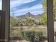 Breathtaking mountain view framed by a window, overlooking lush greenery and neighborhood homes at 3120 E Squaw Peak Cir, Phoenix, AZ 85016