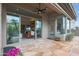 Covered patio featuring ceiling fan, desert landscaping, and multiple sliding glass doors at 3120 E Squaw Peak Cir, Phoenix, AZ 85016