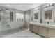 Well-lit bathroom featuring a walk-in shower, double vanity, framed mirrors, and neutral decor at 3555 E Gary Way, Gilbert, AZ 85234