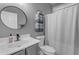 Well-lit bathroom featuring a marble vanity, a round mirror, and a shower with a white curtain at 3555 E Gary Way, Gilbert, AZ 85234