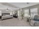 Large main bedroom with carpet, ceiling fan, and sitting area next to sunny windows at 3555 E Gary Way, Gilbert, AZ 85234