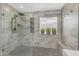 Modern shower with a glass enclosure, rain shower head, bench, and bright window at 3555 E Gary Way, Gilbert, AZ 85234