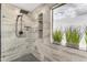 Close-up of shower featuring modern fixtures and gray-patterned tile with built in shelves at 3555 E Gary Way, Gilbert, AZ 85234