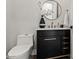 Elegant powder room features stylish black vanity, gold fixtures, and eye-catching textured wall, offering a chic and modern design at 3630 E Coconino Ct, Phoenix, AZ 85044