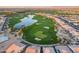 Aerial view featuring a golf course, neighborhood, lake, and mountain backdrop at 37036 N Stoneware Dr, Queen Creek, AZ 85140