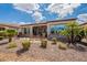 Landscaped backyard includes stone ground cover, lounge seating, and manicured shrubbery at 37036 N Stoneware Dr, Queen Creek, AZ 85140