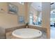 An arched opening leads to a soaking tub with decorative tile surround at 37036 N Stoneware Dr, Queen Creek, AZ 85140