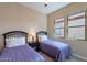 Bedroom with two twin beds with bedside table between them, and a neutral wall color at 37036 N Stoneware Dr, Queen Creek, AZ 85140