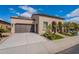 Beautiful home exterior featuring a two-car garage, manicured landscaping, and a welcoming entrance at 37036 N Stoneware Dr, Queen Creek, AZ 85140