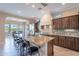 Open kitchen with a large island, bar seating, stainless steel appliances, and views to the dining area at 37036 N Stoneware Dr, Queen Creek, AZ 85140