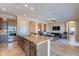 Open-concept kitchen with a large island, stainless steel appliances, and views to the living room at 37036 N Stoneware Dr, Queen Creek, AZ 85140