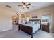 Comfortable main bedroom with large windows, ceiling fan and doorway leading to a ensuite bathroom at 37036 N Stoneware Dr, Queen Creek, AZ 85140