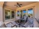 Spacious covered patio with furniture, ceiling fan, and view through large sliding doors at 37036 N Stoneware Dr, Queen Creek, AZ 85140