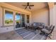 Covered patio with comfortable seating, ceiling fan, and views of yard and community at 37036 N Stoneware Dr, Queen Creek, AZ 85140