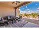 Covered patio with comfortable seating, ceiling fan, and a view of the backyard at 37036 N Stoneware Dr, Queen Creek, AZ 85140
