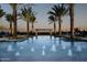 Resort-style pool featuring fountains, lounge chairs and shade umbrellas surrounded by multiple palm trees at 37036 N Stoneware Dr, Queen Creek, AZ 85140