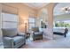 Cozy sitting room with comfortable armchairs and large windows overlooking lush outdoor landscaping at 37036 N Stoneware Dr, Queen Creek, AZ 85140
