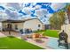 Spacious backyard with artificial turf, a fire pit, and a covered patio area at 4036 E Captain Dreyfus Ave, Phoenix, AZ 85032