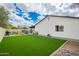 Landscaped backyard featuring artificial turf and a cozy outdoor seating area at 4036 E Captain Dreyfus Ave, Phoenix, AZ 85032