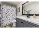 Bathroom with gray vanity, a white countertop, a framed mirror, and a dinosaur-themed shower curtain at 4036 E Captain Dreyfus Ave, Phoenix, AZ 85032